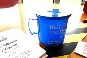 A Mary's Meals collecting box in the shape of cup